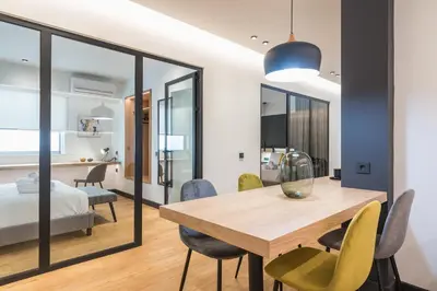 a dining room with a table and chairs and a bedroom at Brand New Ermou Veni Apartment in Athens