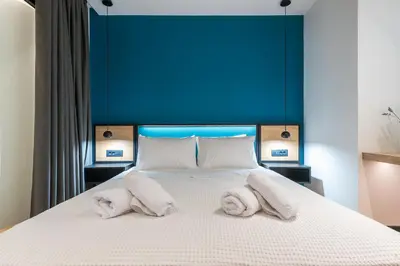 a bedroom with a large bed with towels on it at Brand New Ermou Veni Apartment in Athens