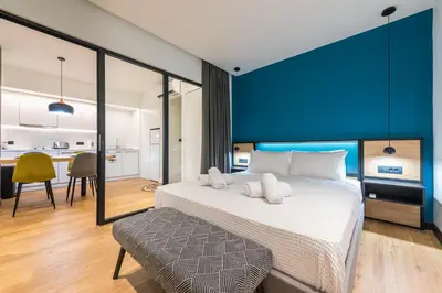 a bedroom with a large bed with a blue wall at Brand New Ermou Veni Apartment in Athens