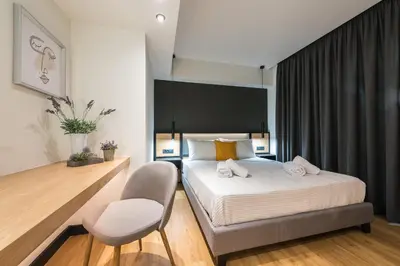 a bedroom with a bed and a chair in it at Brand New Ermou Veni Apartment in Athens