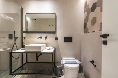 a bathroom with a sink and a toilet and a mirror at Brand New Ermou Veni Apartment in Athens