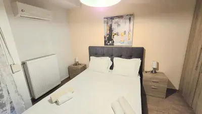 a bedroom with a white bed with two white pillows at Yianna's Apartment in Athens