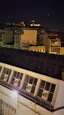 a building with chairs on top of it at night at Yianna's Apartment in Athens