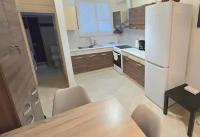 a kitchen with a table and a white refrigerator at Yianna's Apartment in Athens