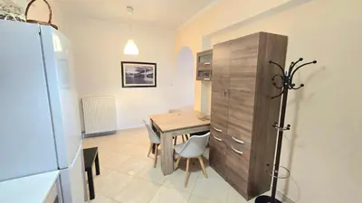 a kitchen with a table and a wooden cabinet at Yianna's Apartment in Athens