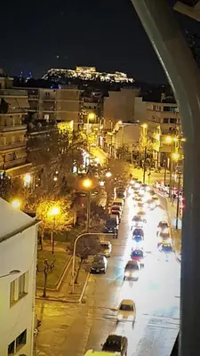 a city street at night with cars parked at Yianna's Apartment in Athens
