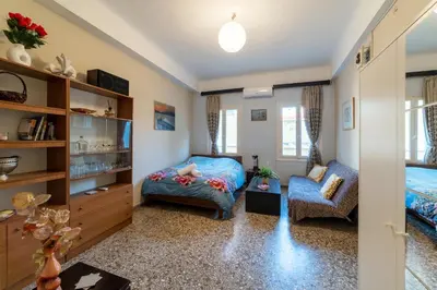 a bedroom with a bed and a chair at Acropolis Quiet House in Athens