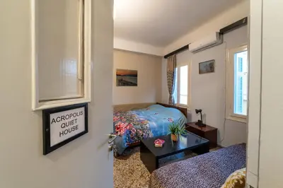 a small bedroom with a bed and a table at Acropolis Quiet House in Athens