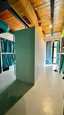 an empty room with a green wall and wooden ceilings at Iconic Athens Hostel in Athens