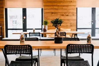 a dining room with tables and chairs and windows at Iconic Athens Hostel in Athens