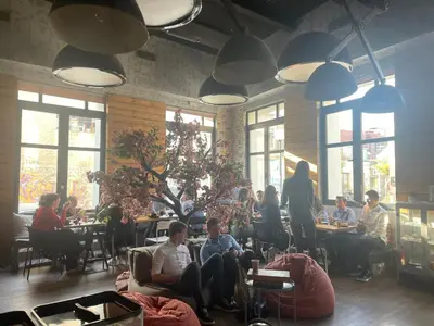 a group of people sitting at tables in a restaurant at Iconic Athens Hostel in Athens