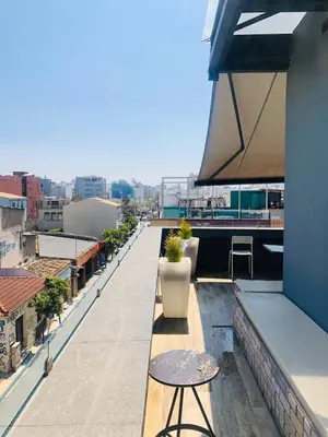 a balcony with a table and a view of a city at Iconic Athens Hostel in Athens