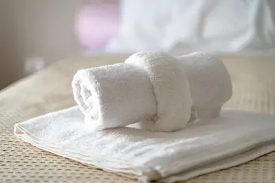 a pile of towels sitting on top of a bed at Family apartment at Kalithea 2 bedrooms 4 pers in Athens