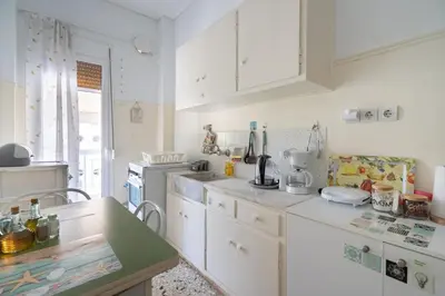 a kitchen with white cabinets and a counter top at Family apartment at Kalithea 2 bedrooms 4 pers in Athens