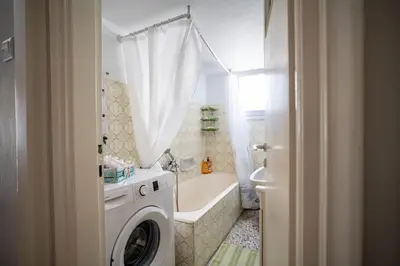 a bathroom with a tub and a washing machine at Family apartment at Kalithea 2 bedrooms 4 pers in Athens