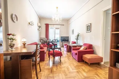 a living room with red furniture and a dining room at Family apartment at Kalithea 2 bedrooms 4 pers in Athens