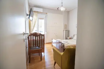 a room with a bedroom with a bed and a chair at Family apartment at Kalithea 2 bedrooms 4 pers in Athens