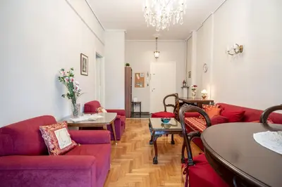 a living room with red couches and a table at Family apartment at Kalithea 2 bedrooms 4 pers in Athens