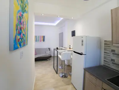 a kitchen with a white refrigerator and a table at Lux Sea Apartment - Porto Rafti in Porto Rafti