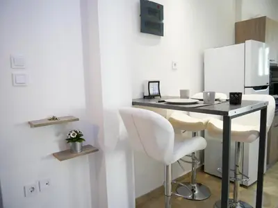 a kitchen with a table and two white chairs at Lux Sea Apartment - Porto Rafti in Porto Rafti