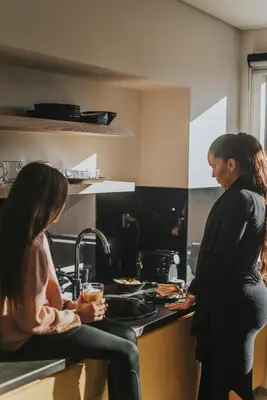 two women standing in a kitchen preparing food at Muse Urban Suites in Athens
