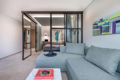 a living room with a blue couch and a bedroom at Muse Urban Suites in Athens