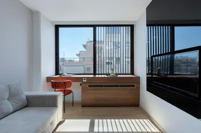 a living room with a couch and a desk with a window at Filopappou Hill Suites by Athens Stay in Athens