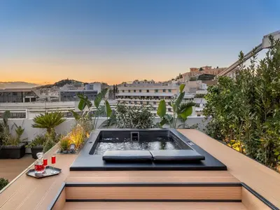 a rooftop patio with a hot tub on a balcony at The Newel Acropolis in Athens