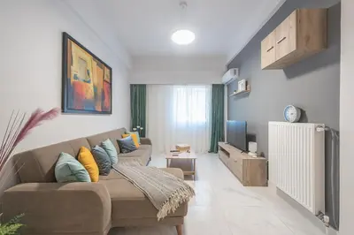 a living room with a couch and a tv at Earthy Green House in Athens