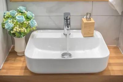a sink with a faucet and flowers in a bathroom at Earthy Green House in Athens