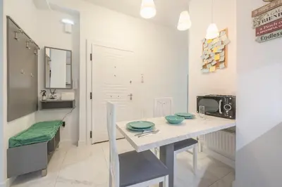 a white kitchen with a table and a microwave at Earthy Green House in Athens