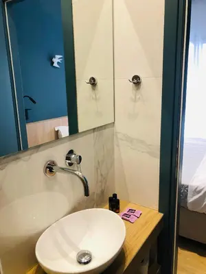 a bathroom with a white sink and a shower at Metropolitan Complex room-Faliro in Piraeus
