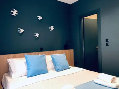 a bedroom with a bed with white butterflies on the wall at Metropolitan Complex room-Faliro in Piraeus