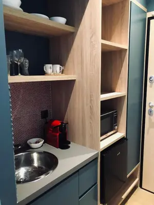 a kitchen with a sink and a microwave at Metropolitan Complex room-Faliro in Piraeus