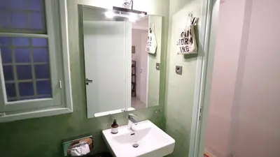 a bathroom with a sink and a mirror at quiet and central FLAT with private backyard GARDEN in Athens