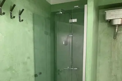 a shower with a glass door in a bathroom at quiet and central FLAT with private backyard GARDEN in Athens