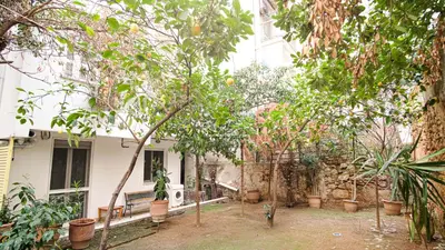 a house with trees and a bench in front of it at quiet and central FLAT with private backyard GARDEN in Athens