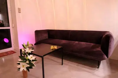 a living room with a brown couch and a table at calm and cozy flat with romantic garden in Athens