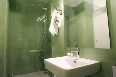 a bathroom with a sink and a shower with a mirror at calm and cozy flat with romantic garden in Athens