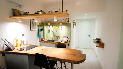 a kitchen with a wooden table and a counter top at calm and cozy flat with romantic garden in Athens