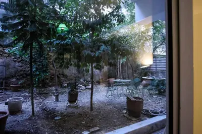 a garden with trees and chairs and a table at calm and cozy flat with romantic garden in Athens