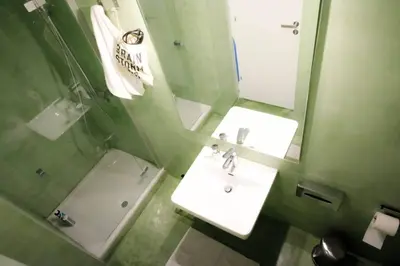 a bathroom with a sink and a mirror and a toilet at calm and cozy flat with romantic garden in Athens