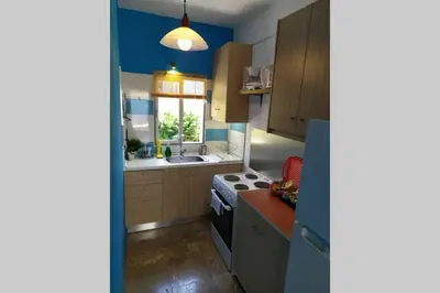 a kitchen with wooden cabinets and a stove top oven at Waterfront Penthouse in Saronida
