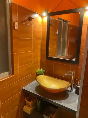 a bathroom with a yellow sink and a mirror at Waterfront Penthouse in Saronida