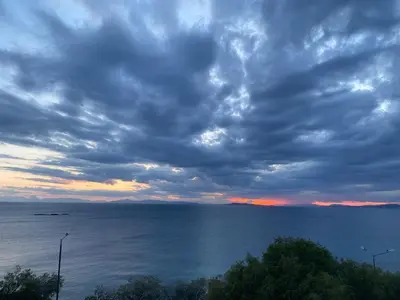 a cloudy sky over the ocean with the horizon at Waterfront Penthouse in Saronida