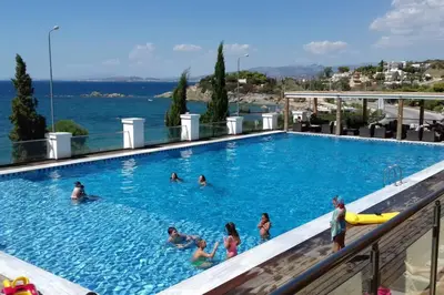 a group of people swimming in a swimming pool at Waterfront Penthouse in Saronida