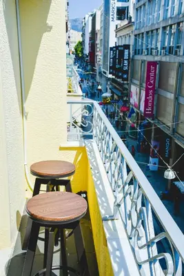 two stools sitting on the balcony of a building at CentraL44 WoW CasuaL Suite-Ermou view in Athens