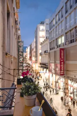 a balcony with a table with plants on a city street at CentraL44 WoW CasuaL Suite-Ermou view in Athens