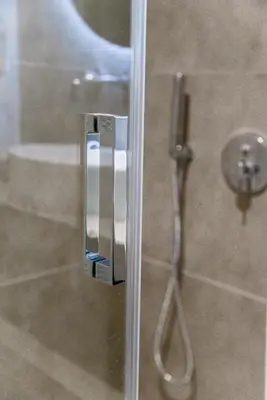 a glass door of a shower with a shower at CentraL44 WoW CasuaL Suite-Ermou view in Athens