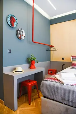 a bedroom with a bed and a table and a stool at CentraL44 WoW CasuaL Suite-Ermou view in Athens